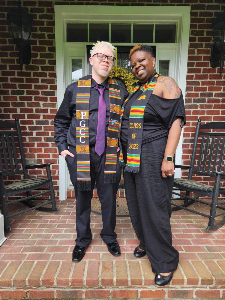 Aaron Wilson and his mother, Kellie Felder, standing on the front porch of their home wearing graduation stoles.