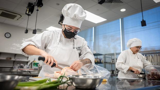 Culinary student training with poultry