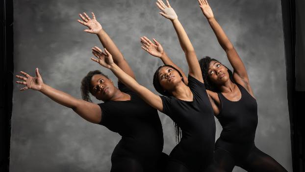 Three students in a modern dance performance