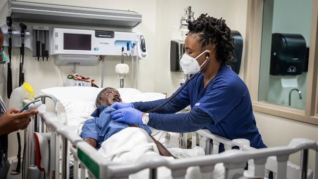 Nursing student using training dummy