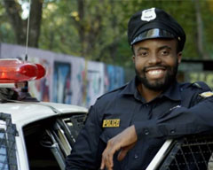 Police officer standing by police cruiser