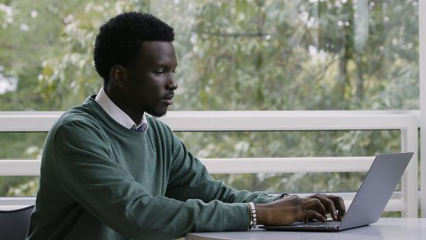 Student studying on a laptop in a common area